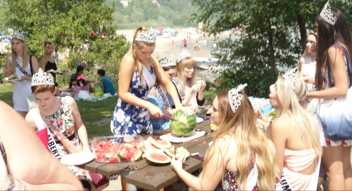 Miss Teen Calgary cutting watermelon for the masses at the beach